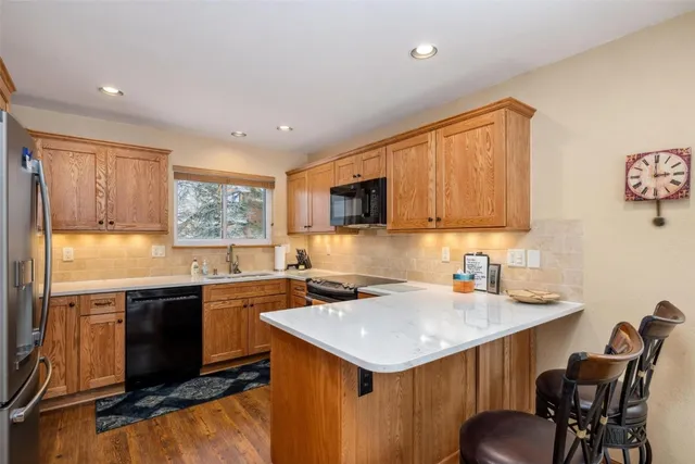 a kitchen with stainless steel appliances a sink window and cabinets