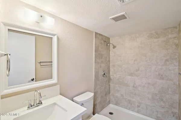 an empty room with windows and ceiling fan