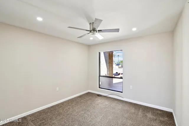 an empty room with a ceiling fan and shower