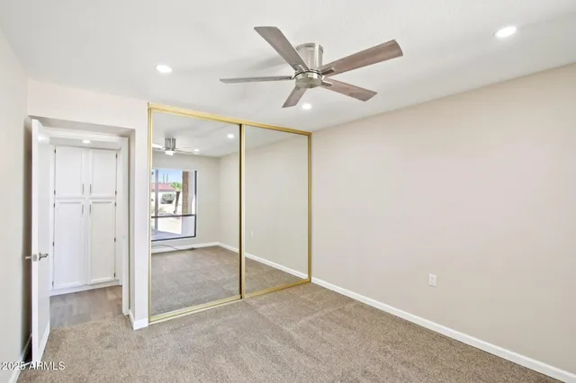 an empty room with a ceiling fan and windows