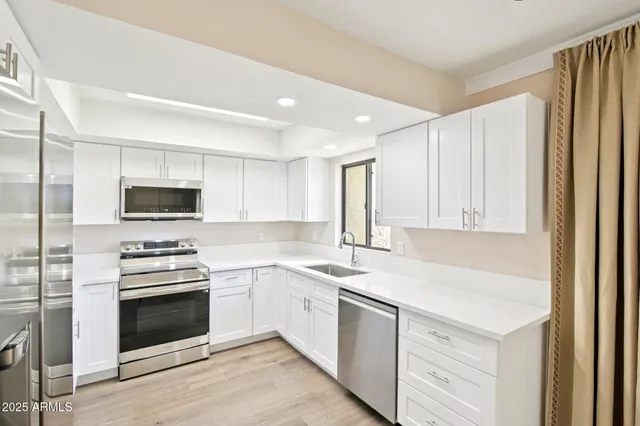 a kitchen with stainless steel appliances a stove a sink and a refrigerator