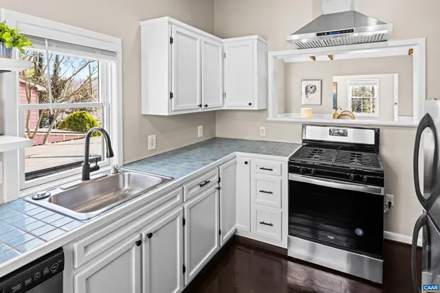 a kitchen with granite countertop a stove sink and cabinets