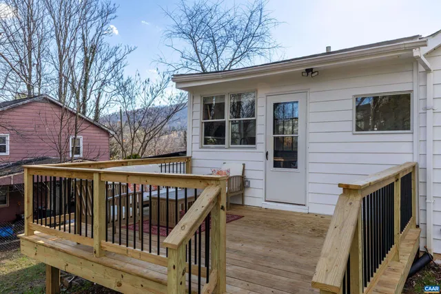 a view of a white house with a large tree