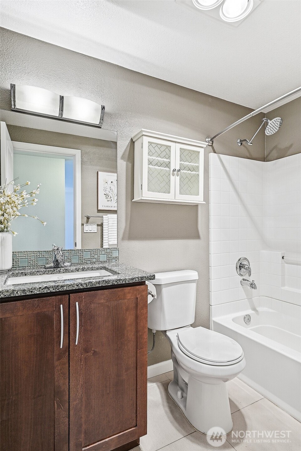 3045 20th Avenue West, Unit 409 Seattle, WA 98199 - Photo 14 of 25 a bathroom with a granite countertop bathtub sink vanity mirror and toilet