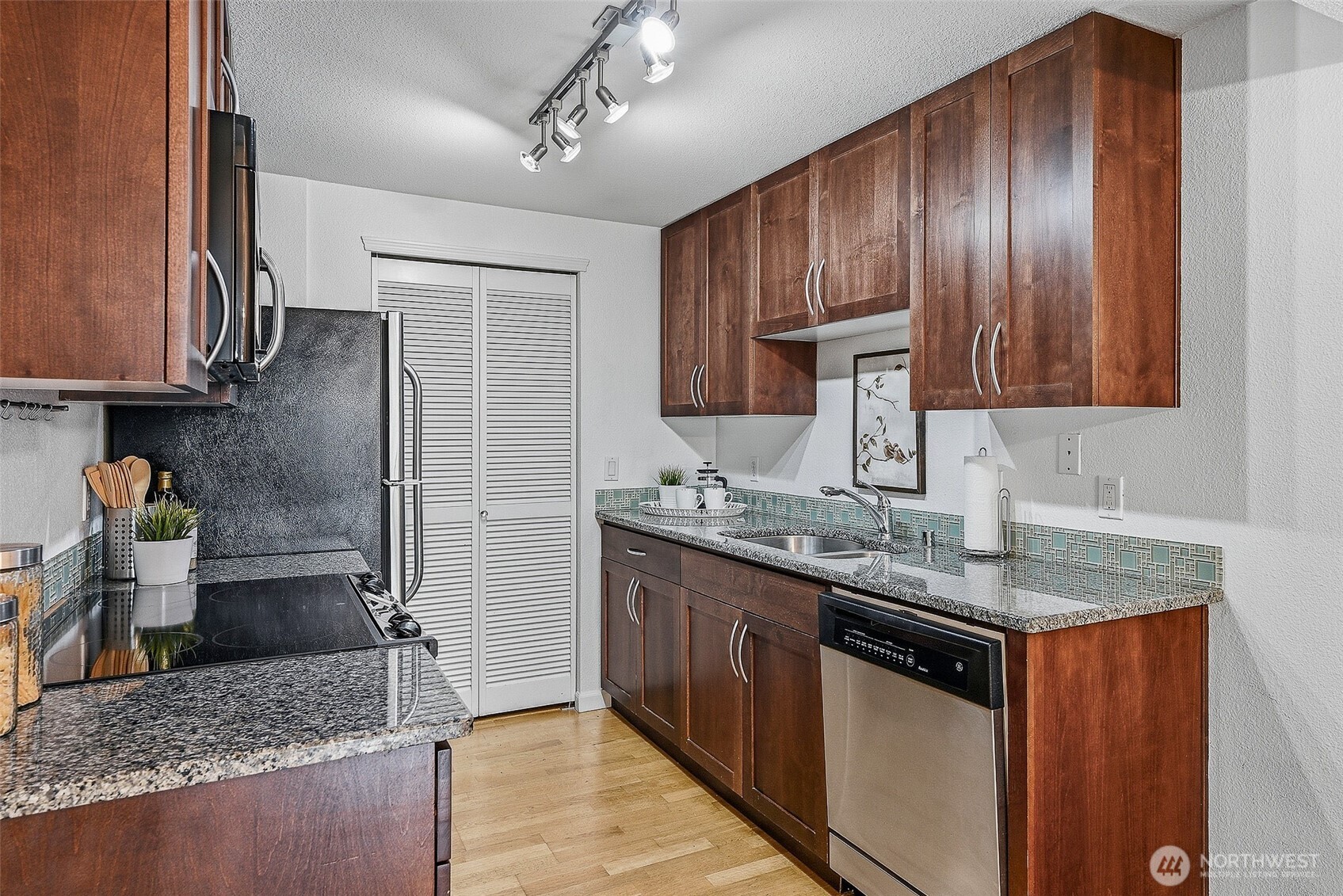 3045 20th Avenue West, Unit 409 Seattle, WA 98199 - Photo 8 of 25 a kitchen with stainless steel appliances granite countertop a sink stove and refrigerator