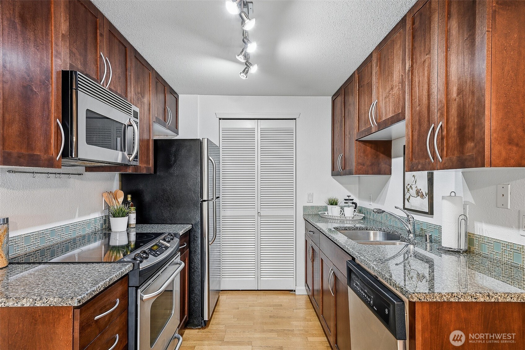 3045 20th Avenue West, Unit 409 Seattle, WA 98199 - Photo 9 of 25 a kitchen with stainless steel appliances granite countertop a sink stove and refrigerator