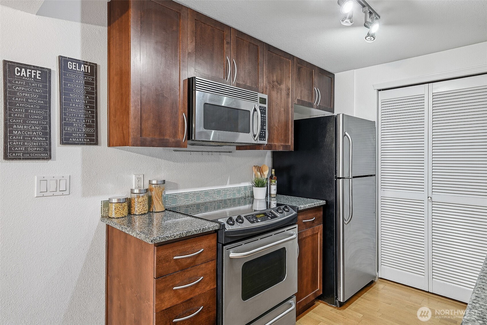 3045 20th Avenue West, Unit 409 Seattle, WA 98199 - Photo 10 of 25 a kitchen with stainless steel appliances granite countertop a stove microwave and refrigerator