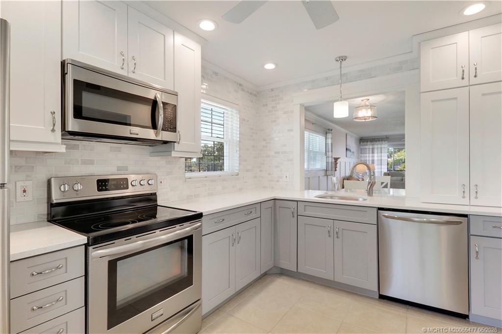 1852 Southwest Palm City Road, Unit 201 Stuart, FL 34994 - Photo 15 of 34 a kitchen with white cabinets and stainless steel appliances