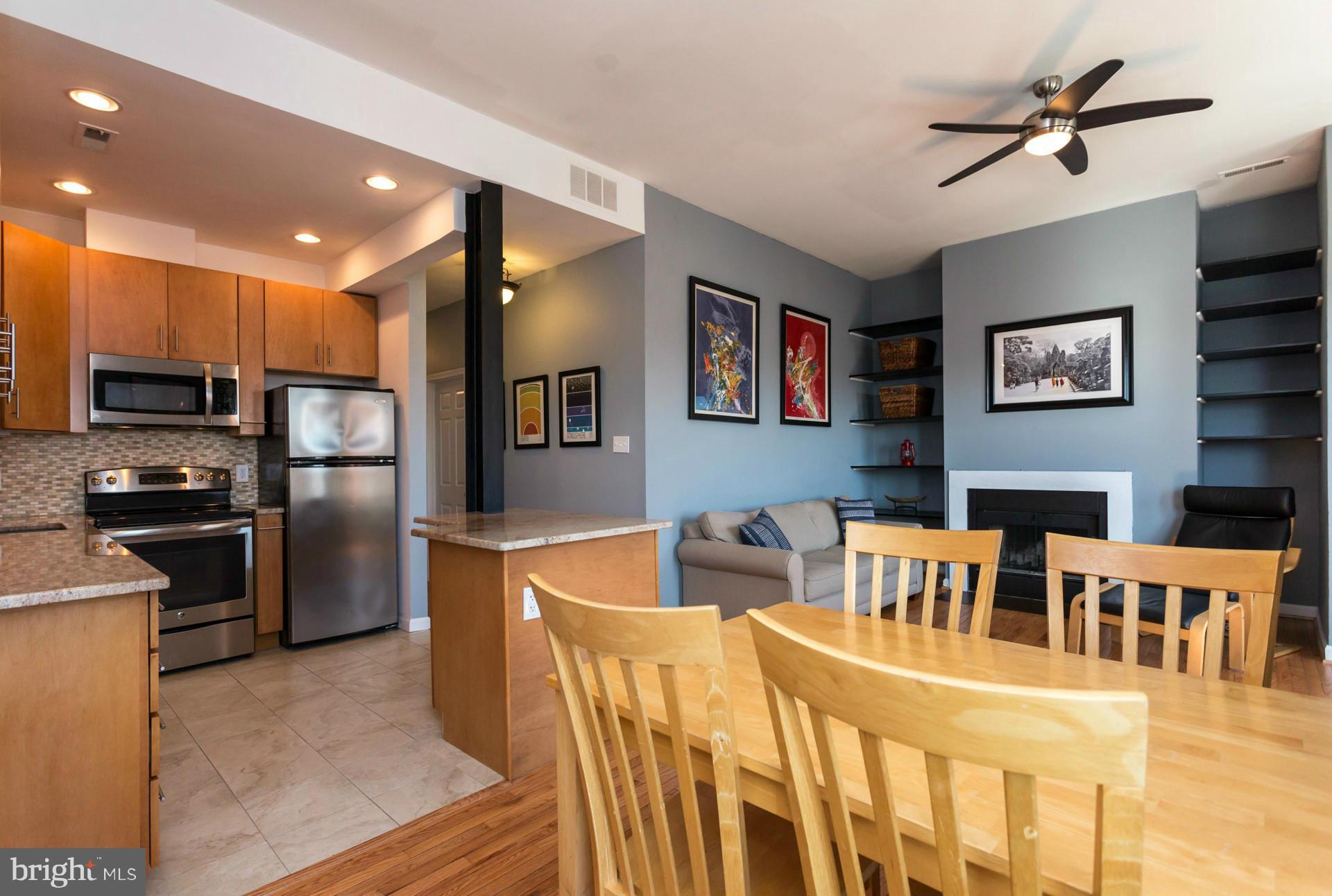 1918 18th Street Northwest, Unit 41 Washington, DC 20009 - Photo 12 of 30 a kitchen with stainless steel appliances kitchen island granite countertop a refrigerator a stove a microwave oven a sink with island and chairs