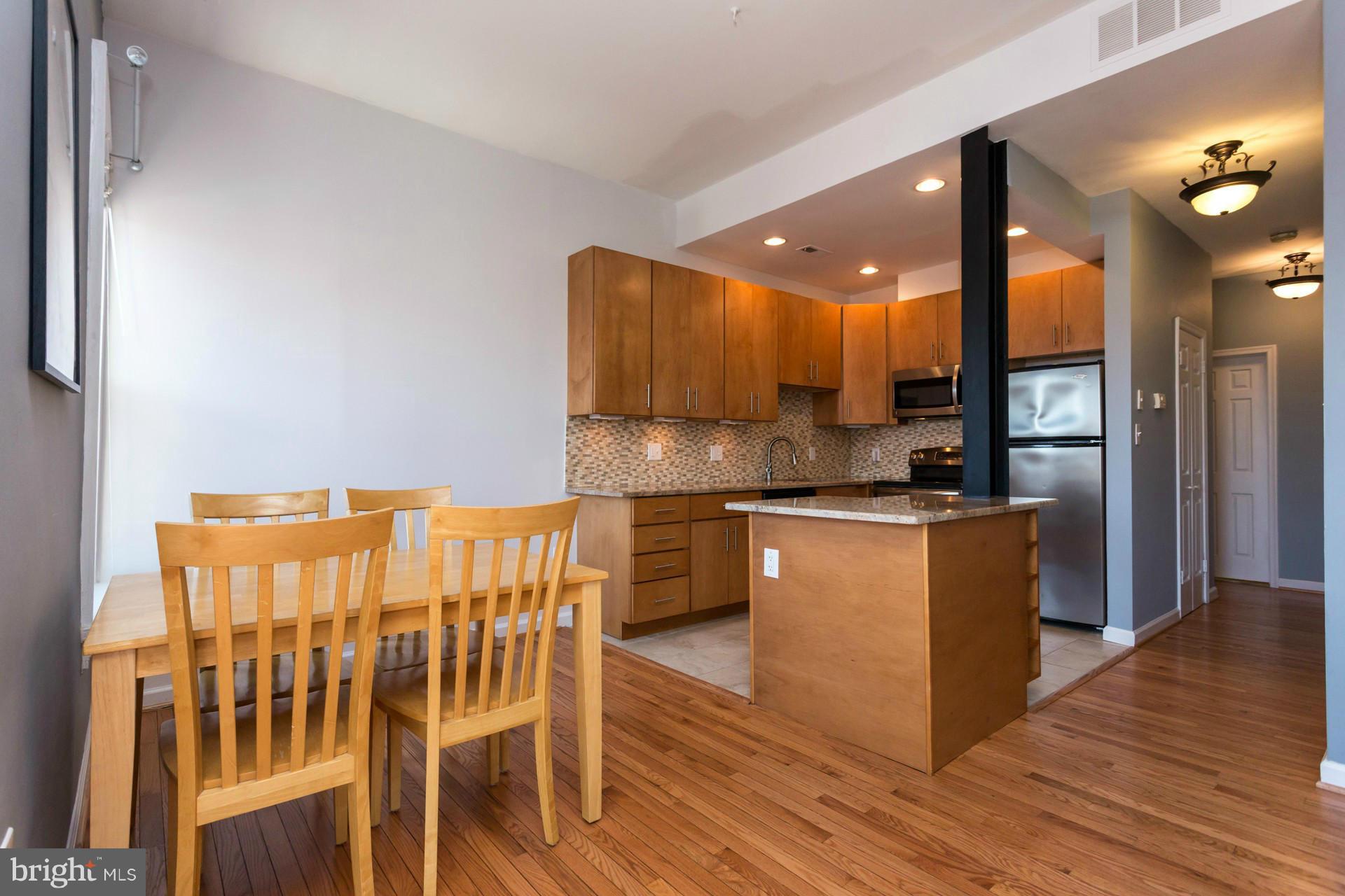 1918 18th Street Northwest, Unit 41 Washington, DC 20009 - Photo 10 of 30 a kitchen with kitchen island granite countertop wooden floors and a sink