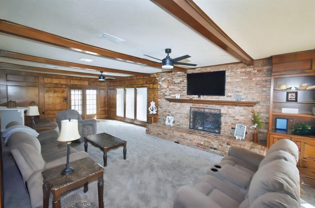 802 West Coke Road Winnsboro, TX 75494 - Photo 15 of 40 a living room with furniture a fireplace and a flat screen tv