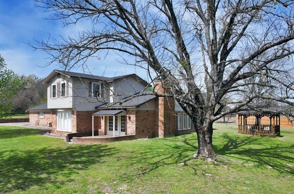 802 West Coke Road Winnsboro, TX 75494 - Photo 3 of 40 a view of house with a big yard and large trees
