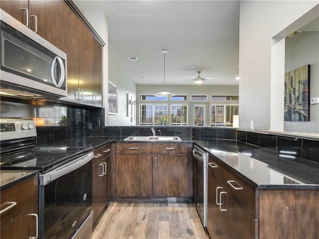2918 Ranch Road 620 North, Unit W221 Austin, TX 78734 - Photo 6 of 20 a kitchen with a sink stove and cabinets