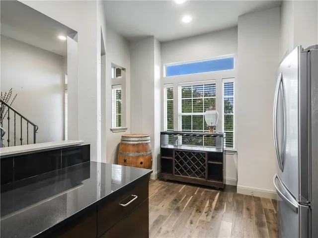 a kitchen with stainless steel appliances kitchen island granite countertop a table chairs and a refrigerator