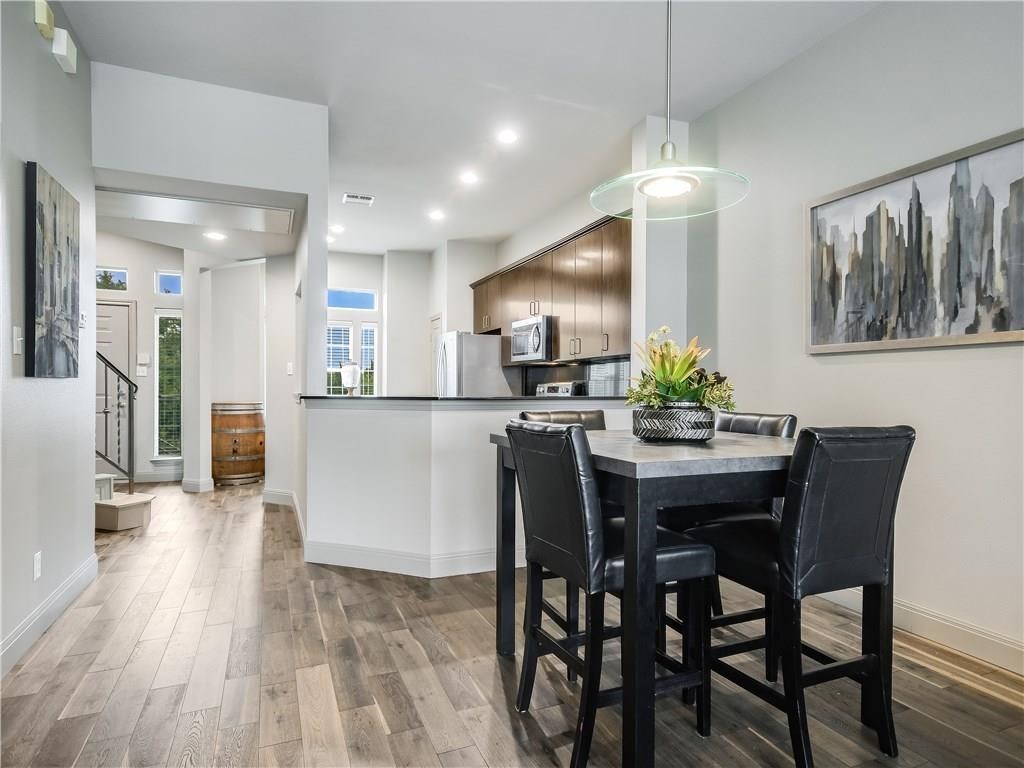 2918 Ranch Road 620 North, Unit W221 Austin, TX 78734 - Photo 8 of 20 a kitchen with stainless steel appliances kitchen island granite countertop a table chairs and a refrigerator