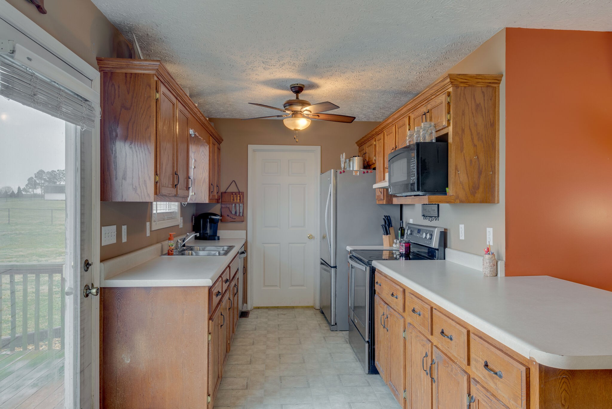 4329 Matthews Road Cedar Hill, TN 37032 - Photo 5 of 17 a kitchen with granite countertop a sink a counter top space stainless steel appliances a flat screen tv and a window