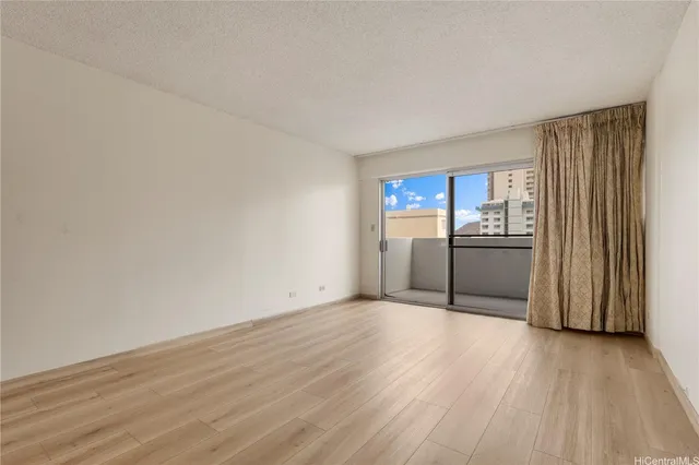 a view of a kitchen with wooden floor electronic appliances and cabinets