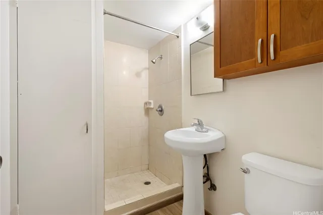 a bathroom with a sink a toilet and shower