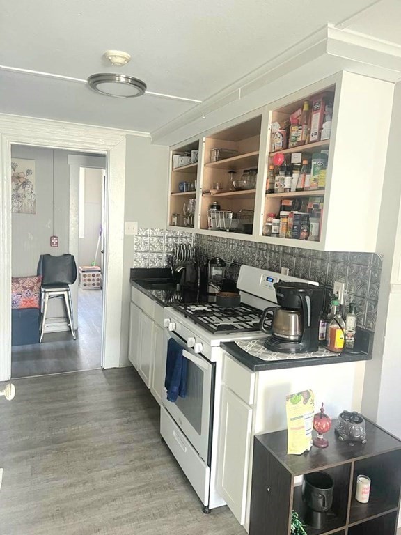 317 Nesmith Street Lowell, MA 01852 - Photo 7 of 16 a kitchen with a stove and a wooden floor