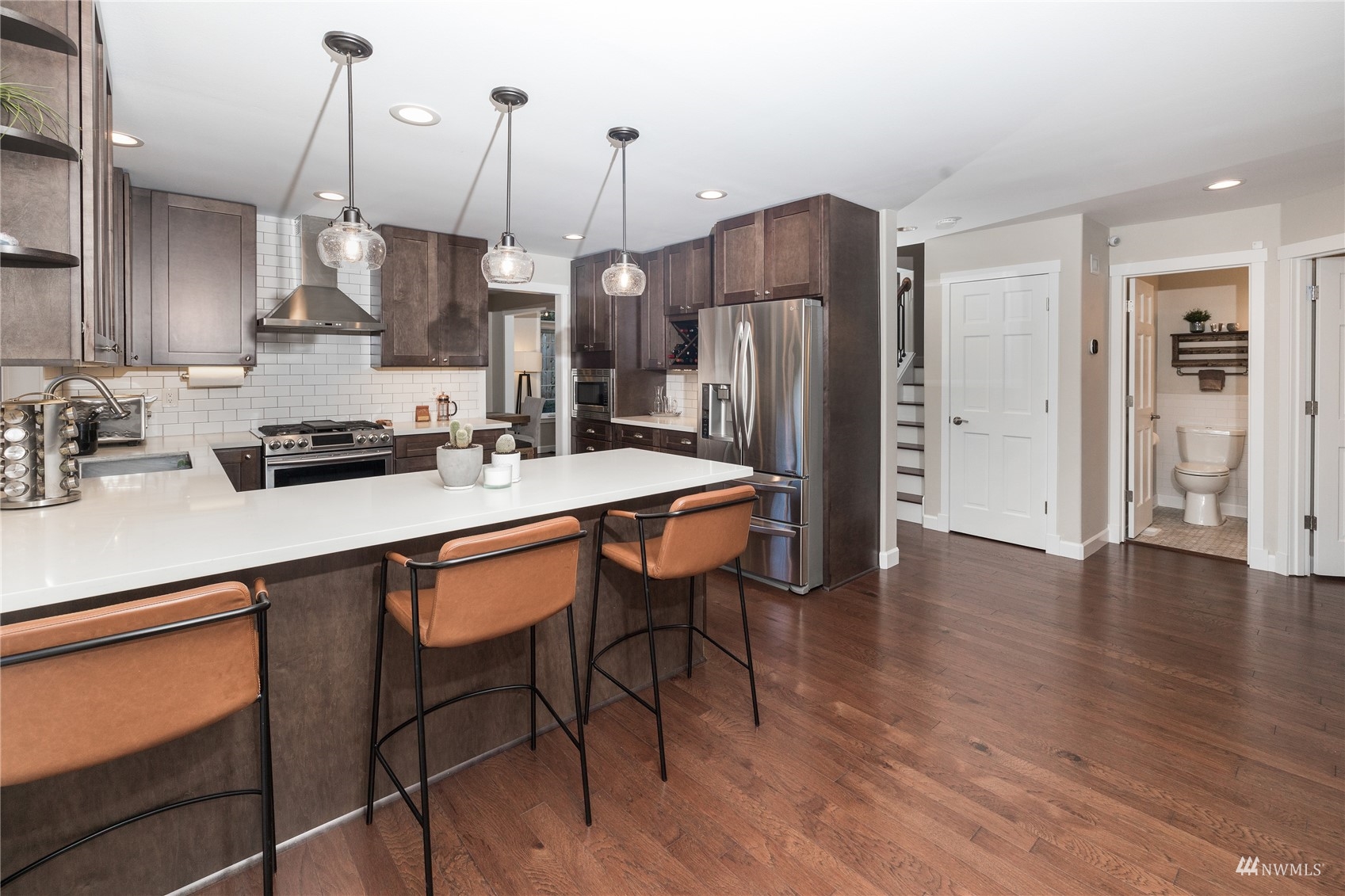 9419 Northeast 175th Street Bothell, WA 98011 - Photo 12 of 28 a kitchen with stainless steel appliances granite countertop a sink a stove a refrigerator and island with wooden floor