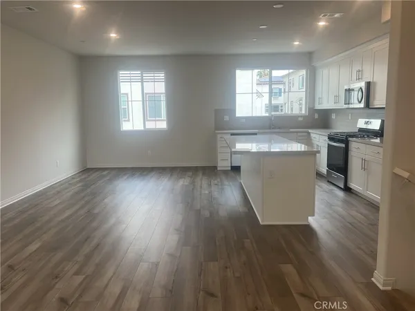 a kitchen with wooden floors and wooden cabinets