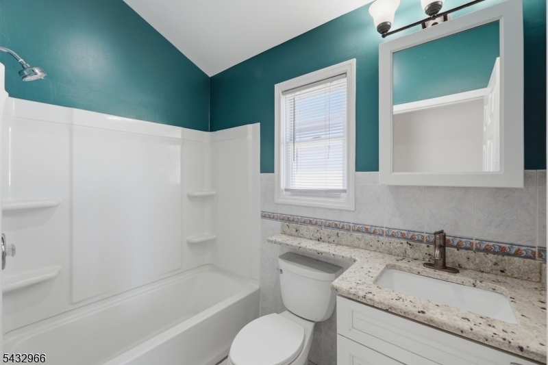 130 3rd Street, Unit 2 Passaic, NJ 07055 - Photo 8 of 12 a bathroom with a granite countertop sink toilet and shower