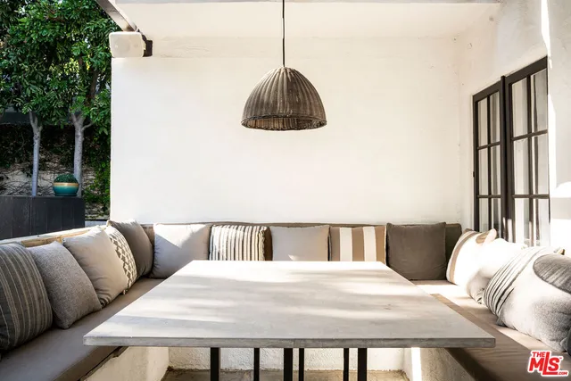 a view of a patio with couches table and chairs and potted plants