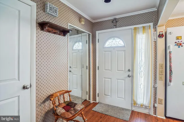 a view of a hallway with wooden floor and closet