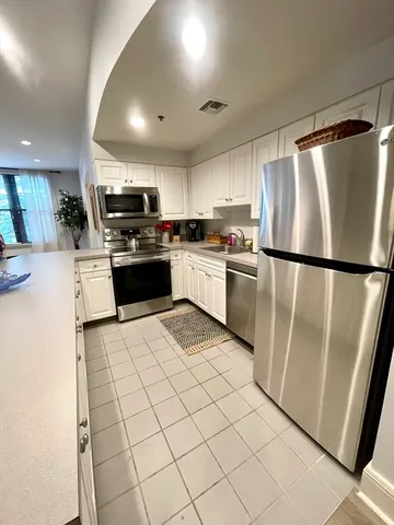 a kitchen with stainless steel appliances granite countertop a refrigerator sink and stove