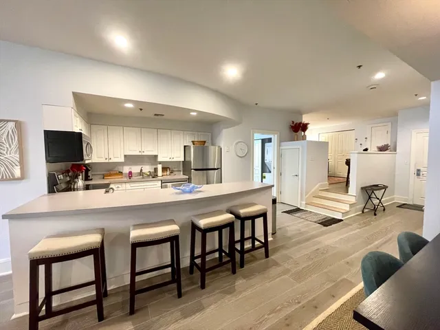 a living room with stainless steel appliances kitchen island granite countertop furniture and a kitchen view