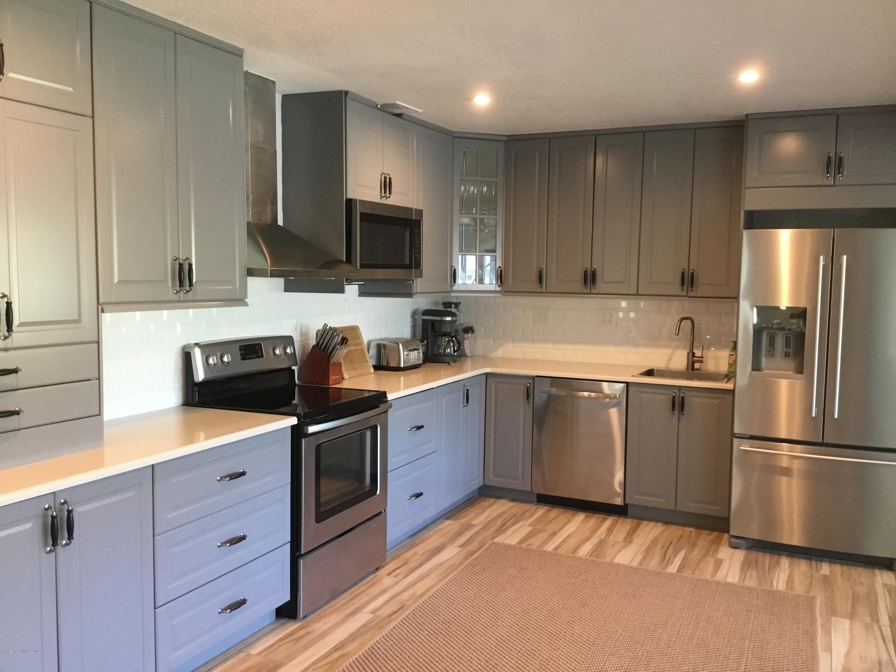 453 Capri Road Cocoa Beach, FL 32931 - Photo 15 of 30 a kitchen with a sink stainless steel appliances and cabinets