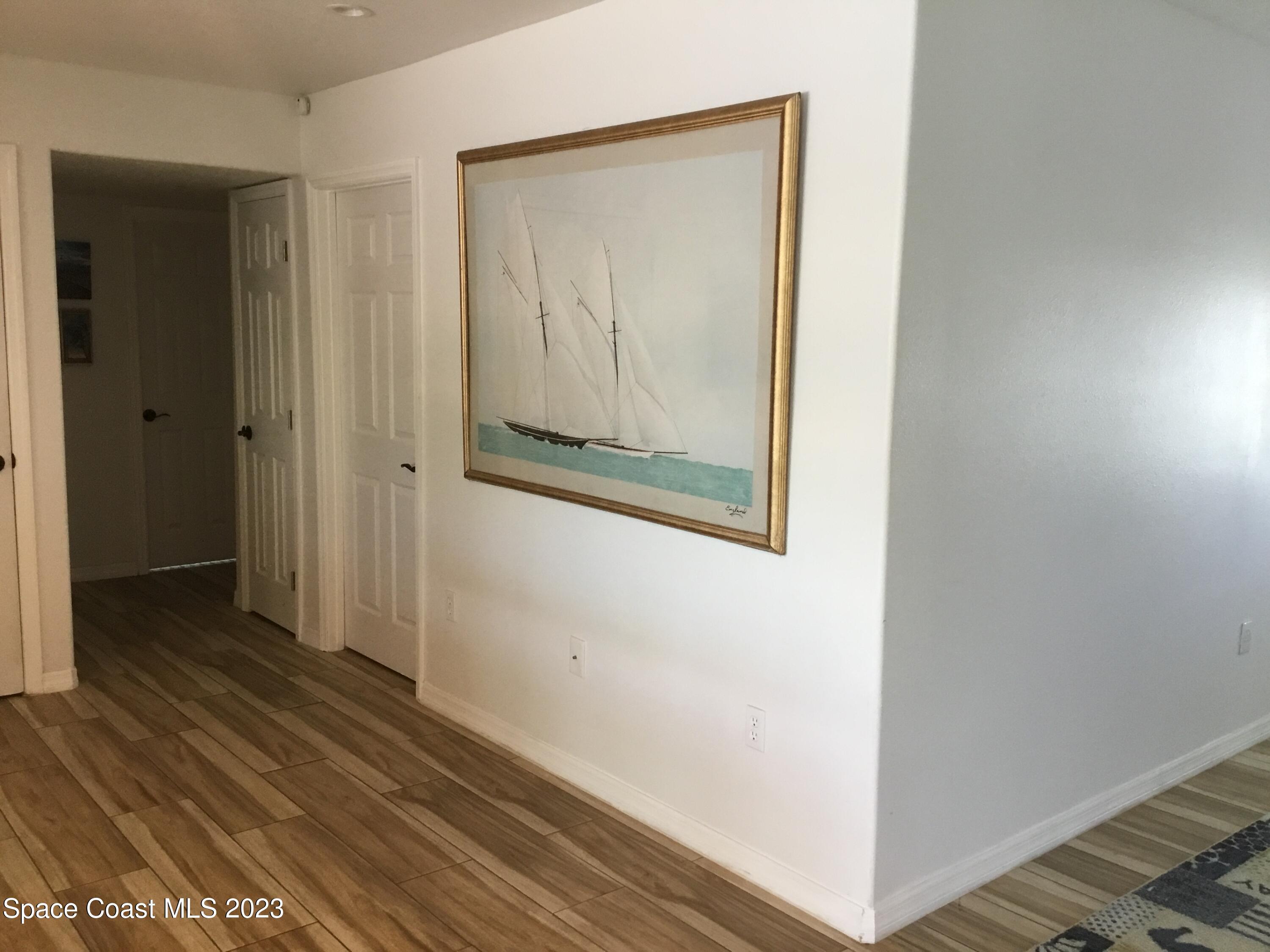 453 Capri Road Cocoa Beach, FL 32931 - Photo 26 of 30 a view of a hallway with wooden floor
