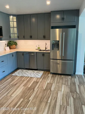 a kitchen with granite countertop a refrigerator and a sink