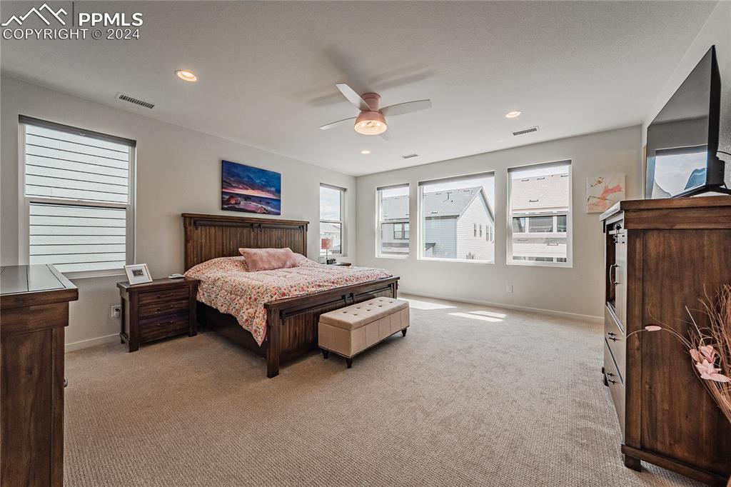 11148 Cloud Shadow Road Littleton, CO 80125 - Photo 26 of 46 a spacious bedroom with a large bed and a tv