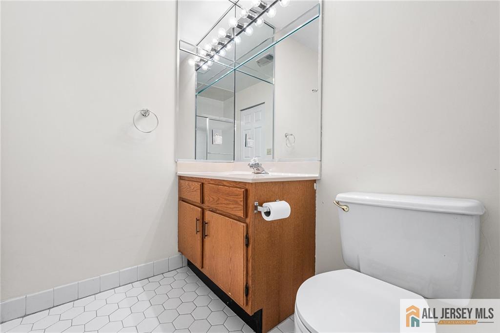 11A Rothwell Drive, Unit 11D Monroe Township, NJ 08831 - Photo 27 of 43 a bathroom with a sink a toilet a vanity and mirror