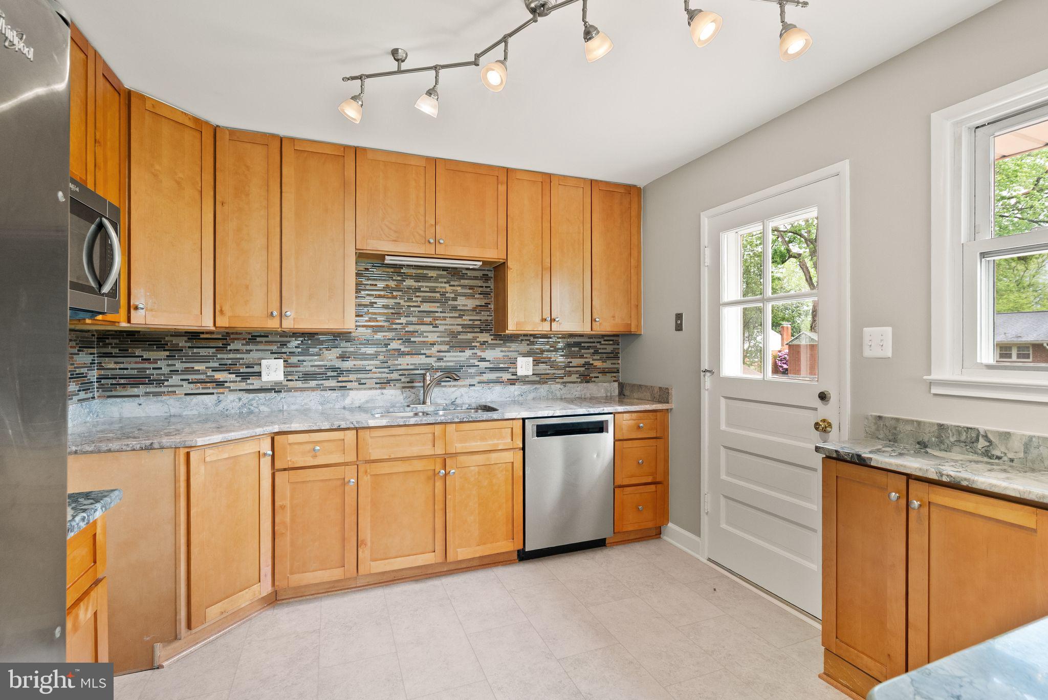 5301 Nutting Drive Springfield, VA 22151 - Photo 4 of 43 a kitchen with granite countertop white cabinets sink and window