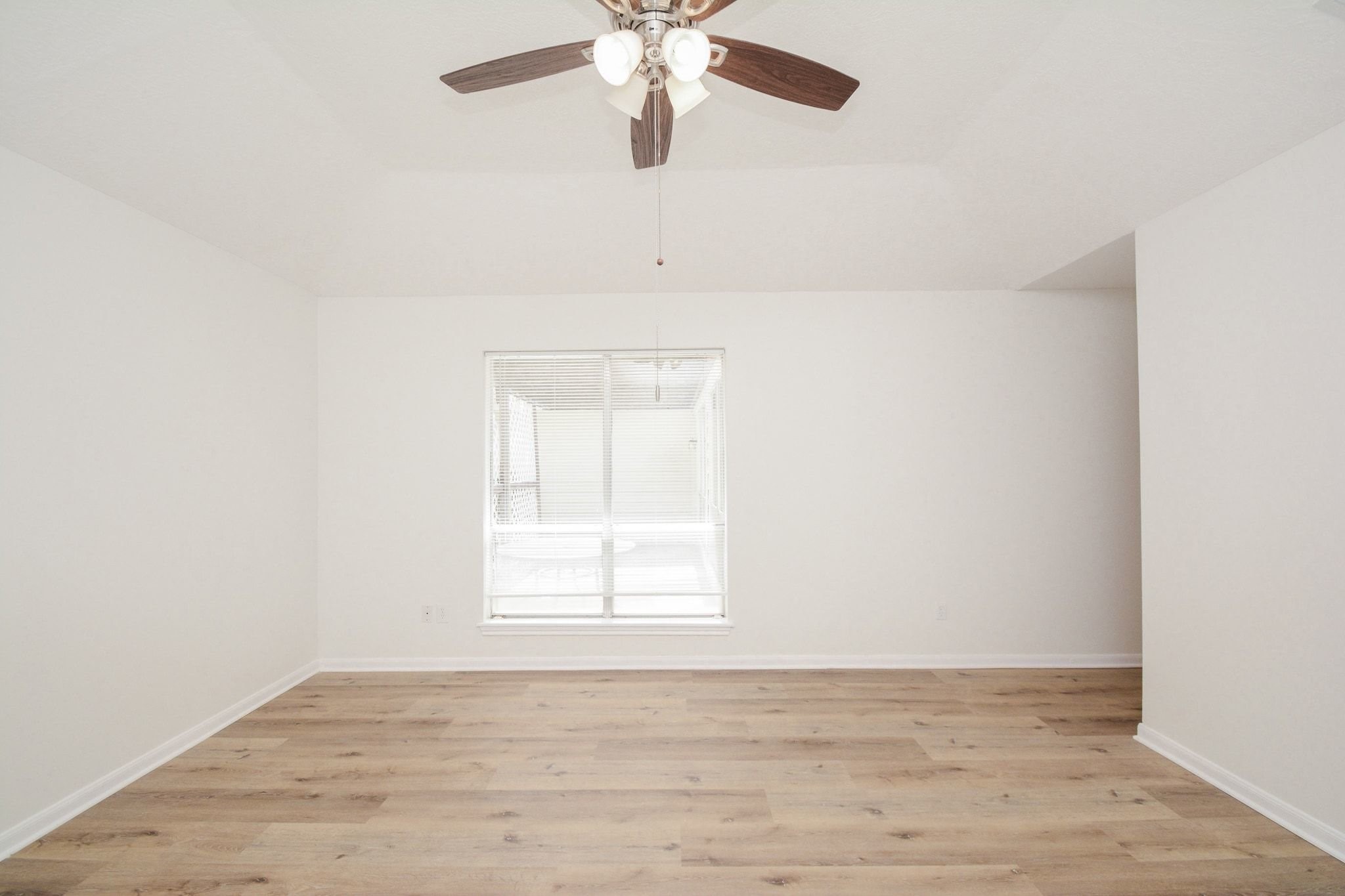 10811 Vickijohn Court Houston, TX 77071 - Photo 11 of 20 an empty room with wooden floor chandelier fan and windows