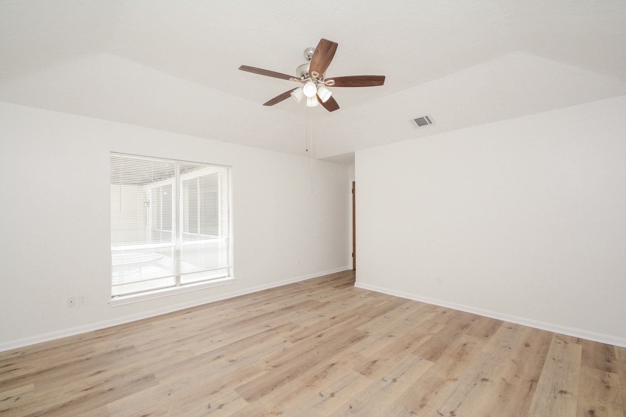 10811 Vickijohn Court Houston, TX 77071 - Photo 12 of 20 an empty room with wooden floor ceiling fan and windows