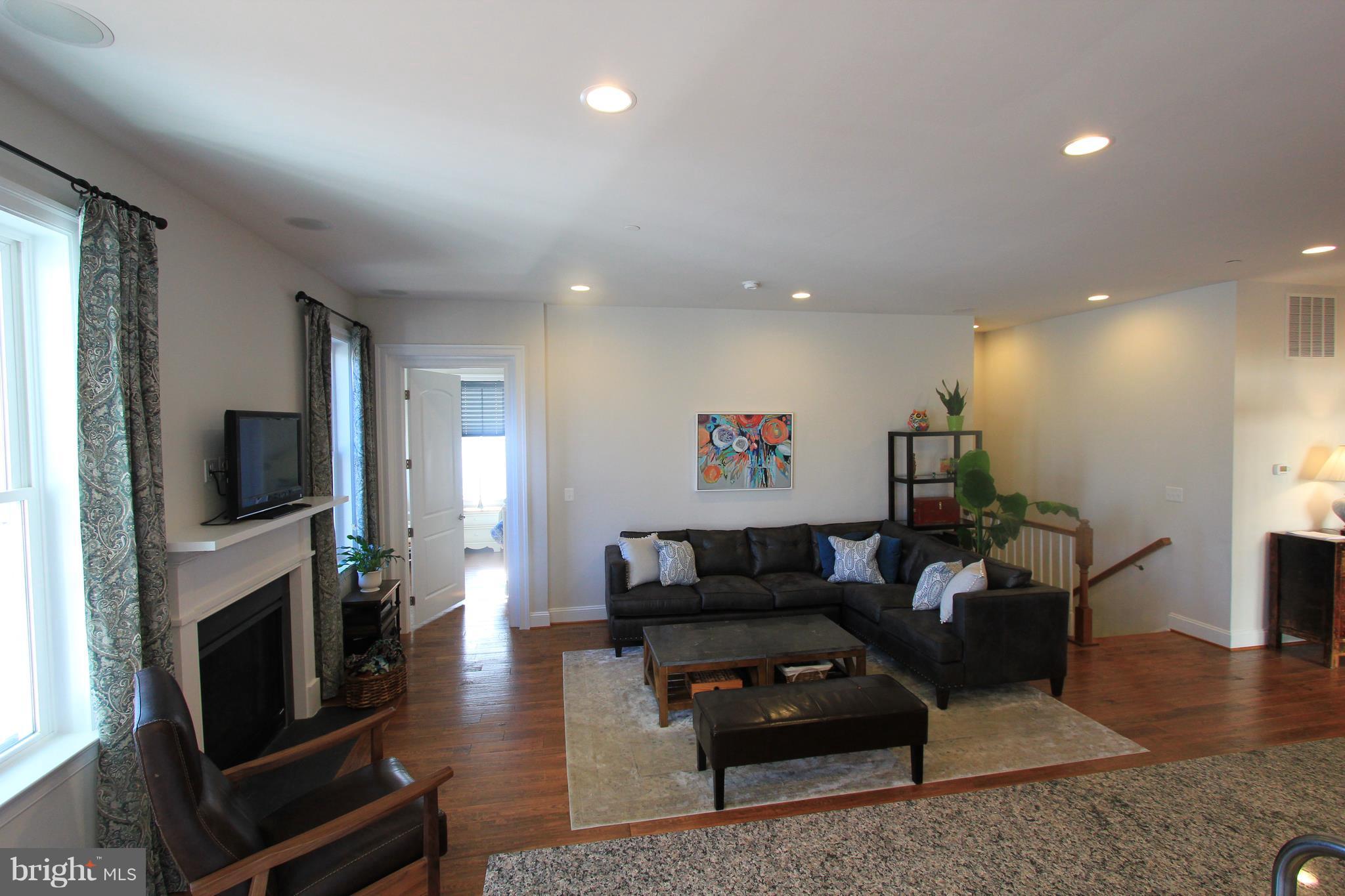 2972 Levee Drive Odenton, MD 21113 - Photo 3 of 30 a living room with furniture a flat screen tv and a fireplace