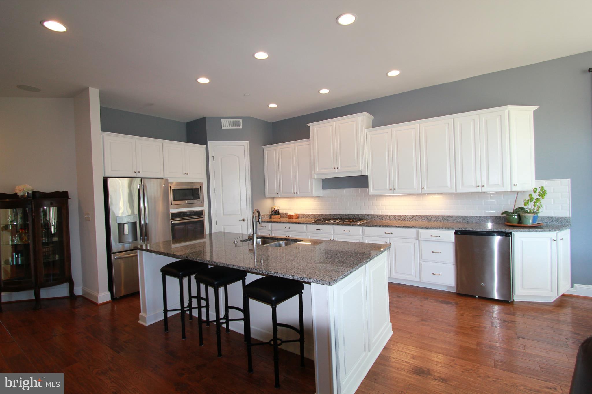 2972 Levee Drive Odenton, MD 21113 - Photo 7 of 30 a kitchen with stainless steel appliances granite countertop a table chairs sink refrigerator and microwave
