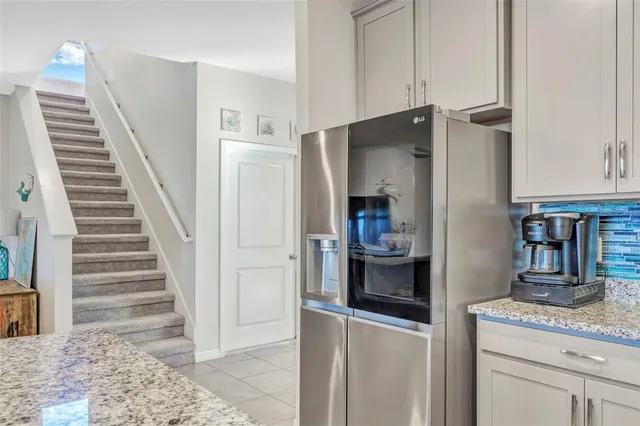 a kitchen with granite countertop a refrigerator and a sink