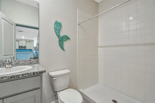 a bathroom with a granite countertop sink a toilet and shower
