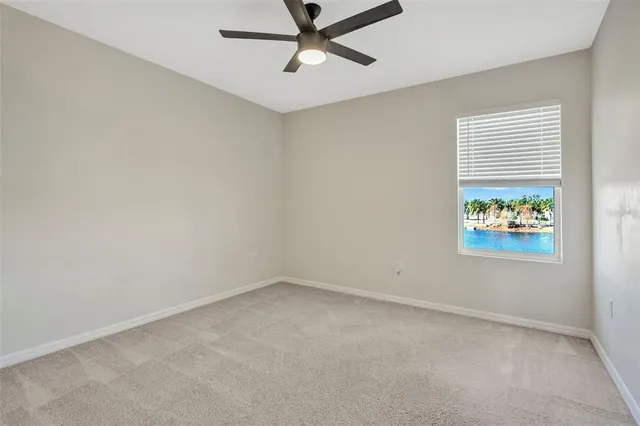 an empty room with a ceiling fan and glass door