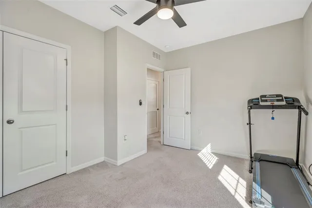 a spacious bedroom with a bed and a flat screen tv