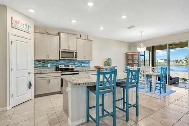a kitchen with appliances cabinets and chair