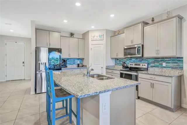 a kitchen with stainless steel appliances granite countertop a stove refrigerator sink and cabinets