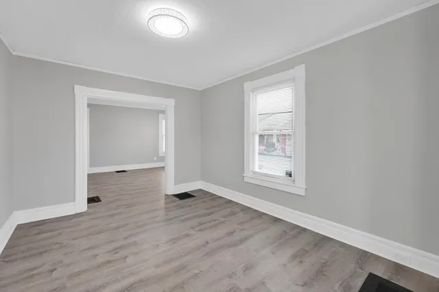 an empty room with wooden floor and entrance