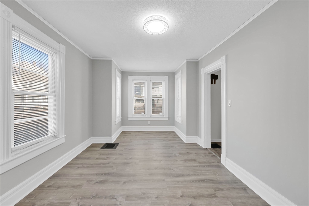 140-142 Dickinson Street Springfield, MA 01108 - Photo 20 of 42 a view of an empty room with wooden floor and a window