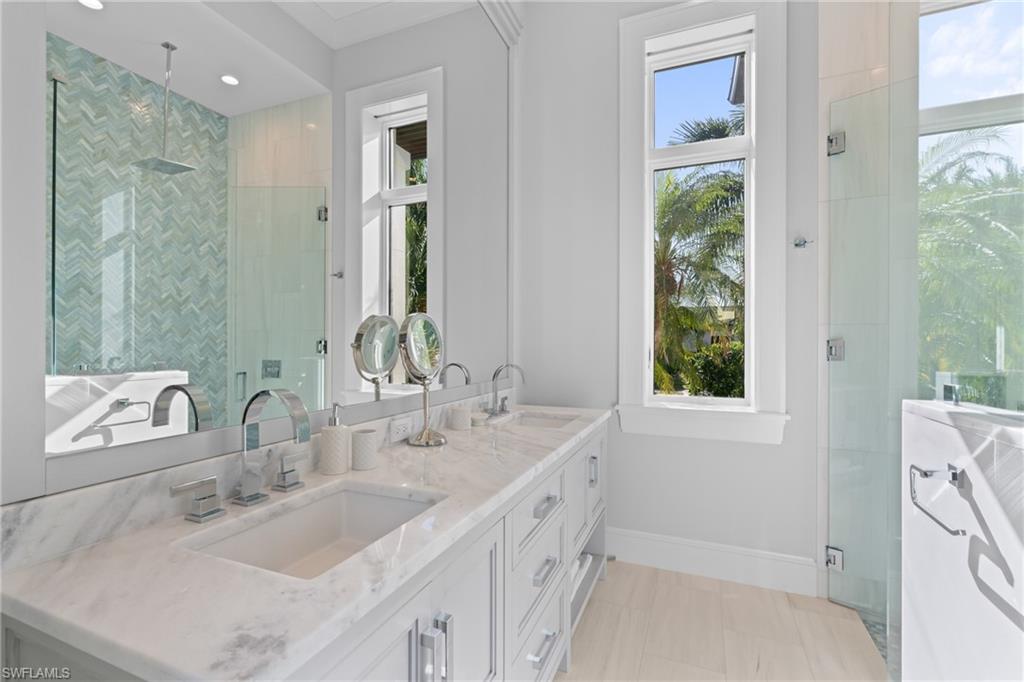 4511 Crayton Road Naples, FL 34103 - Photo 16 of 28 a bathroom with double vanity and a mirror