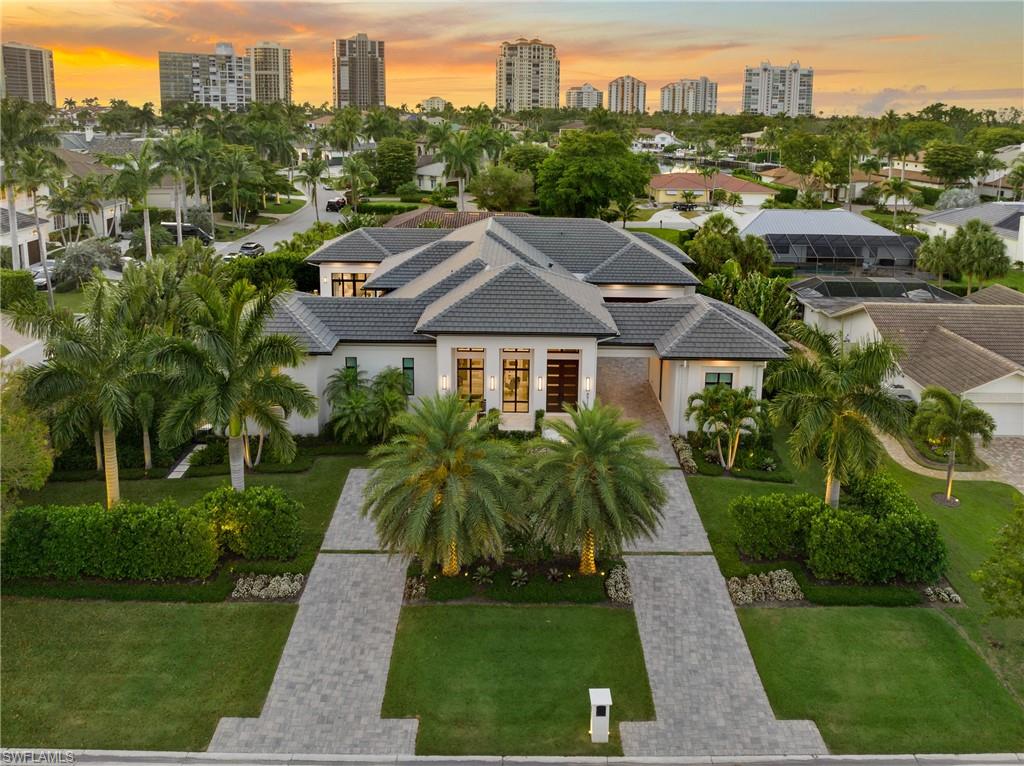 4511 Crayton Road Naples, FL 34103 - Photo 2 of 28 a front view of a residential apartment building with a yard